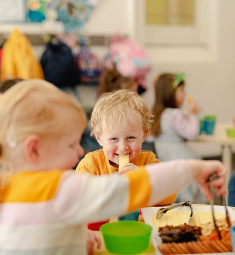 Children enjoying a healthy snack at a childcare centre, promoting nutrition and social interaction during early childhood education.