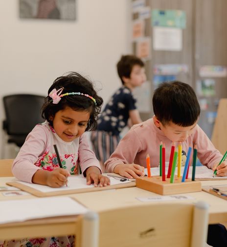 Children coloring at a childcare centre, engaging in creative activities that promote early learning and fine motor skill development.