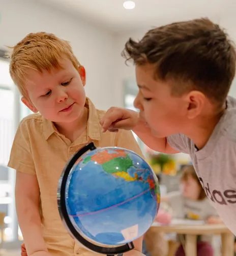 A child exploring a globe at the child care centre, symbolizing a global approach to care and growth in childcare services