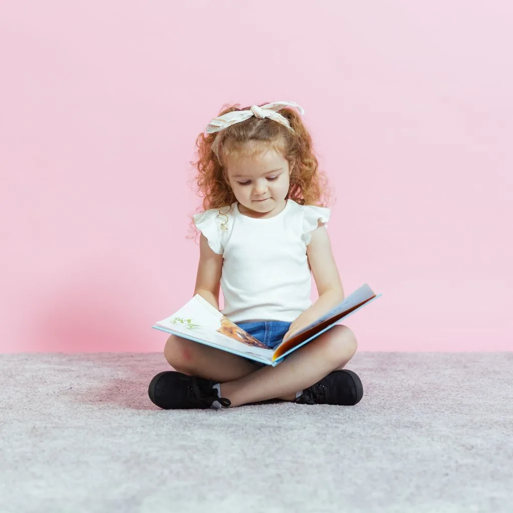 A child reading a book at the child care centre, emphasizing excellence in their childcare services