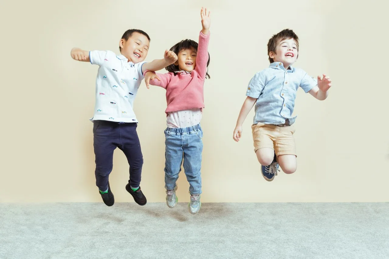 Children jumping with joy at the child care centre, reflecting the fun and care in their childcare services